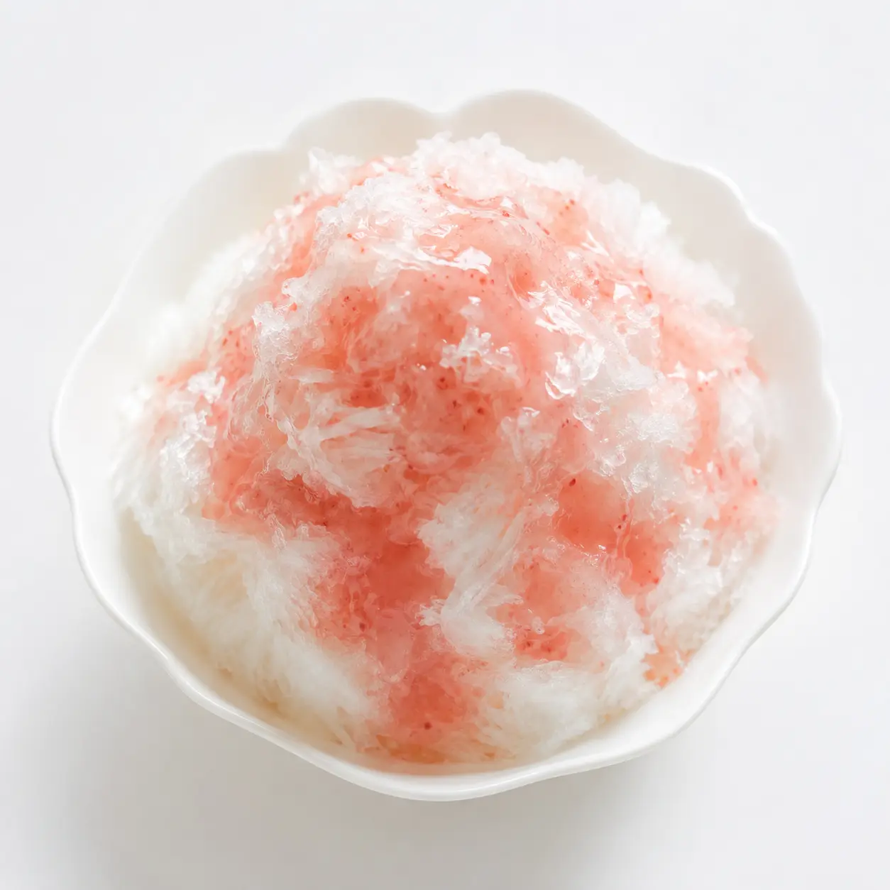 白い器に盛られた、いちごシロップがかかったふわふわのかき氷